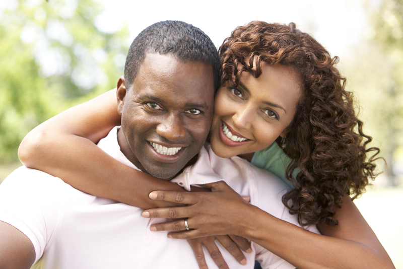 Portrait Of Young Couple Sitting In Park
