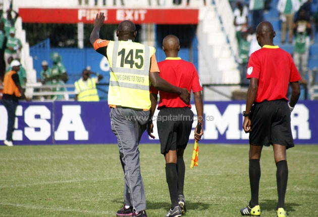 A Gor Mahia steward takes referee George Mwangi back to teh touchline while calming fans during the match against Tusker FC/PHOTO-Raymond Makhaya